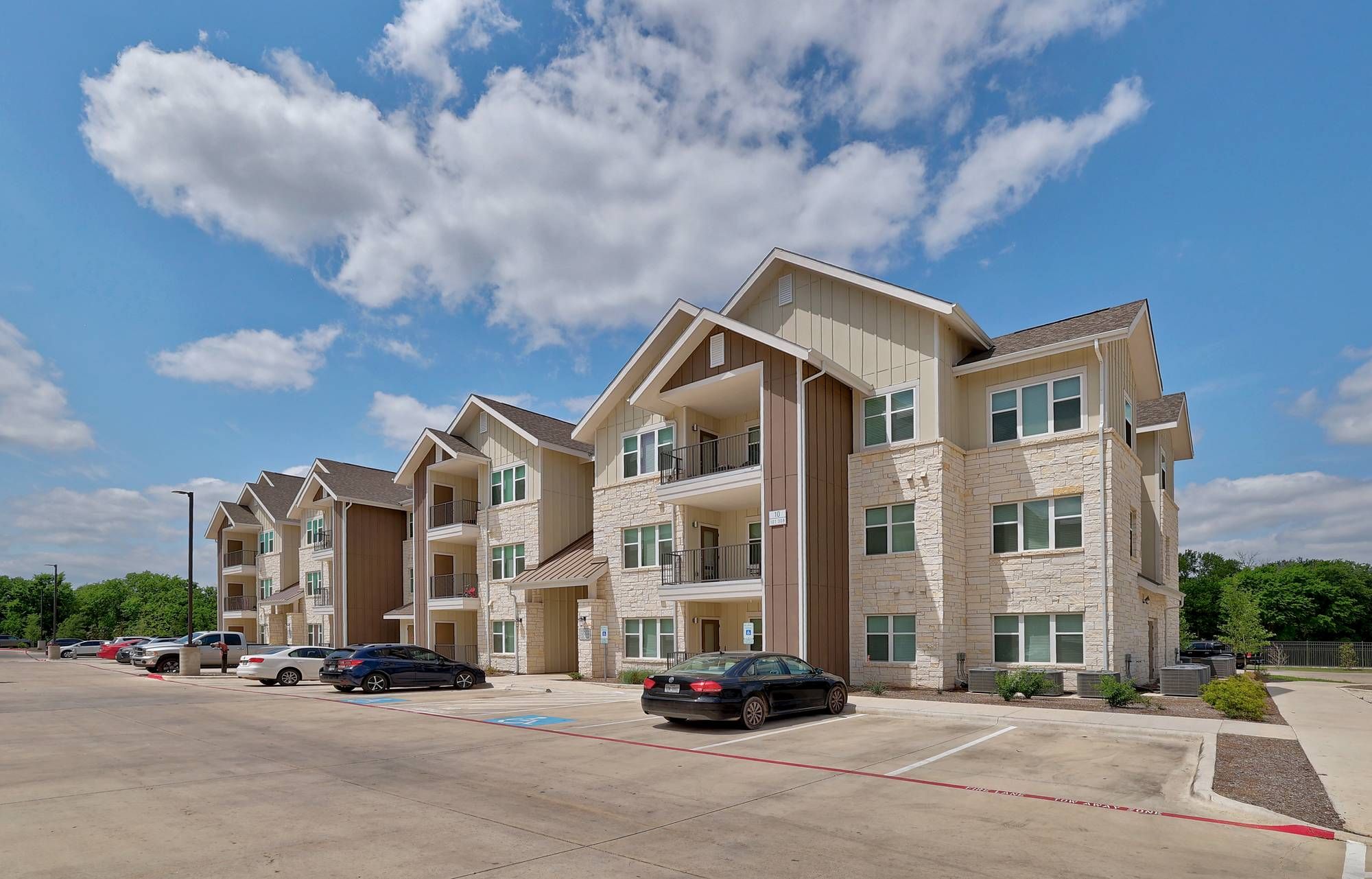 The Narrows A row of apartment buildings with cars parked in front of them.