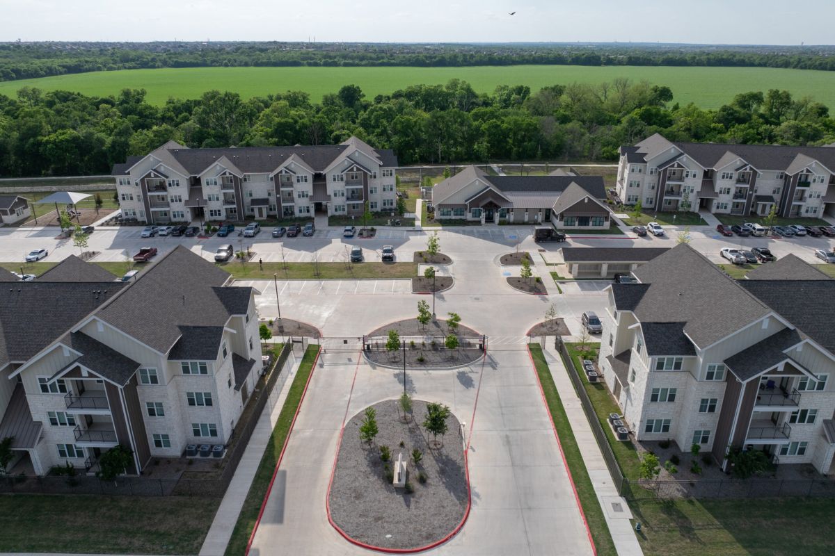 The Narrows Aerial view of an apartment complex with parking lots and green fields in the background.