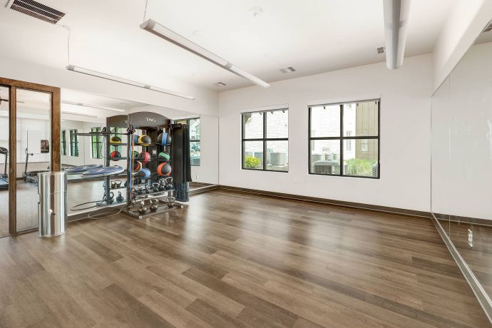 The Narrows Spacious fitness room with exercise balls, mirrors, wooden floor, and large windows letting in natural light.