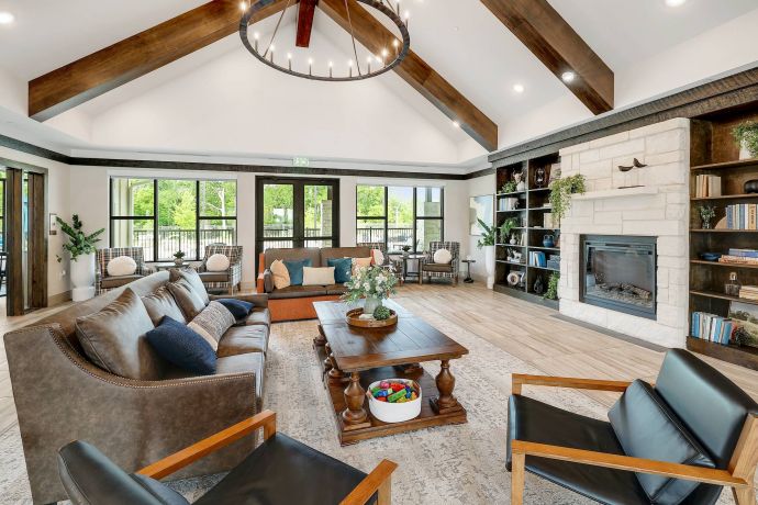 The Narrows Modern living room with vaulted ceiling, fireplace, bookshelves, sofas, and large windows letting in natural light.