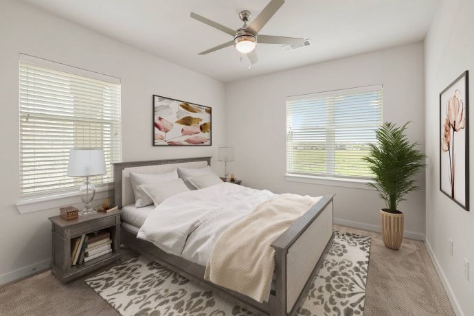 The Narrows A bright bedroom with a bed, nightstand, plant, wall art, and two large windows letting in sunlight.